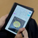 Huion Note Eを手に持って文字を描いている